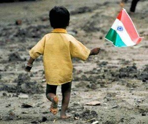 A homeless young boy waves the Indian flag
