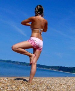 Woman performing Yoga on a Beach