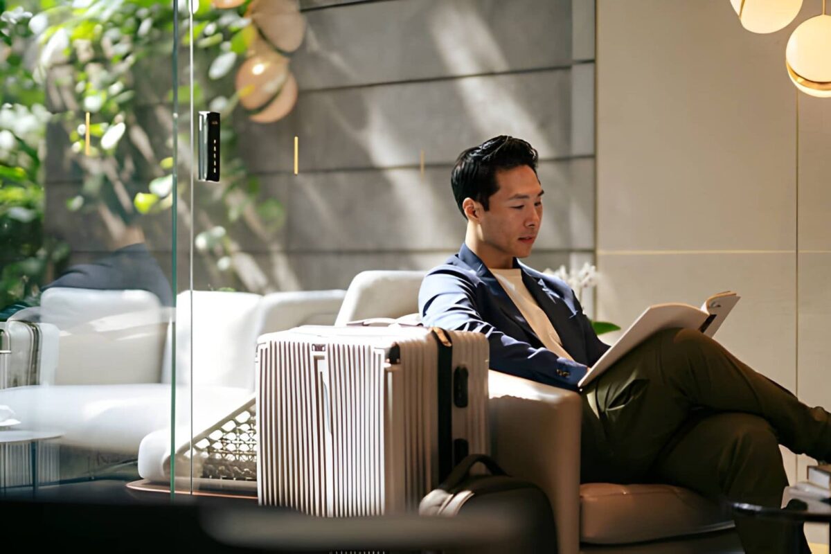 Well dressed affluent Asian business traveler relaxing in an airport lounge