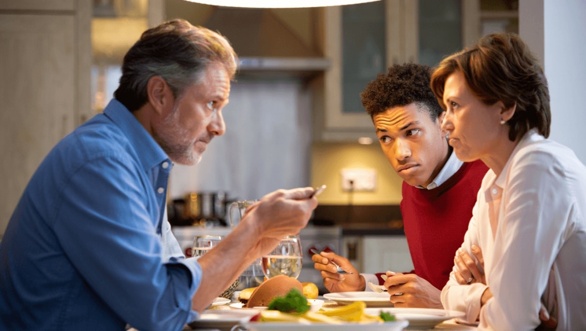 two women facing each other on a couch with serious expressions