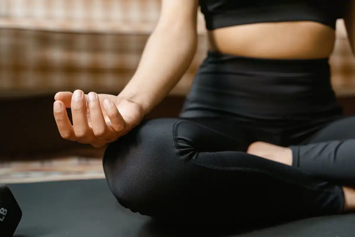 Person in a calm meditative posture practicing mindfulness and breathing techniques for mental health support