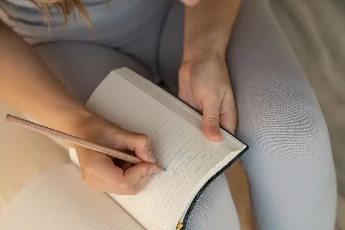 Individual writing in a journal as part of a reflective wellness practice and personal growth routine