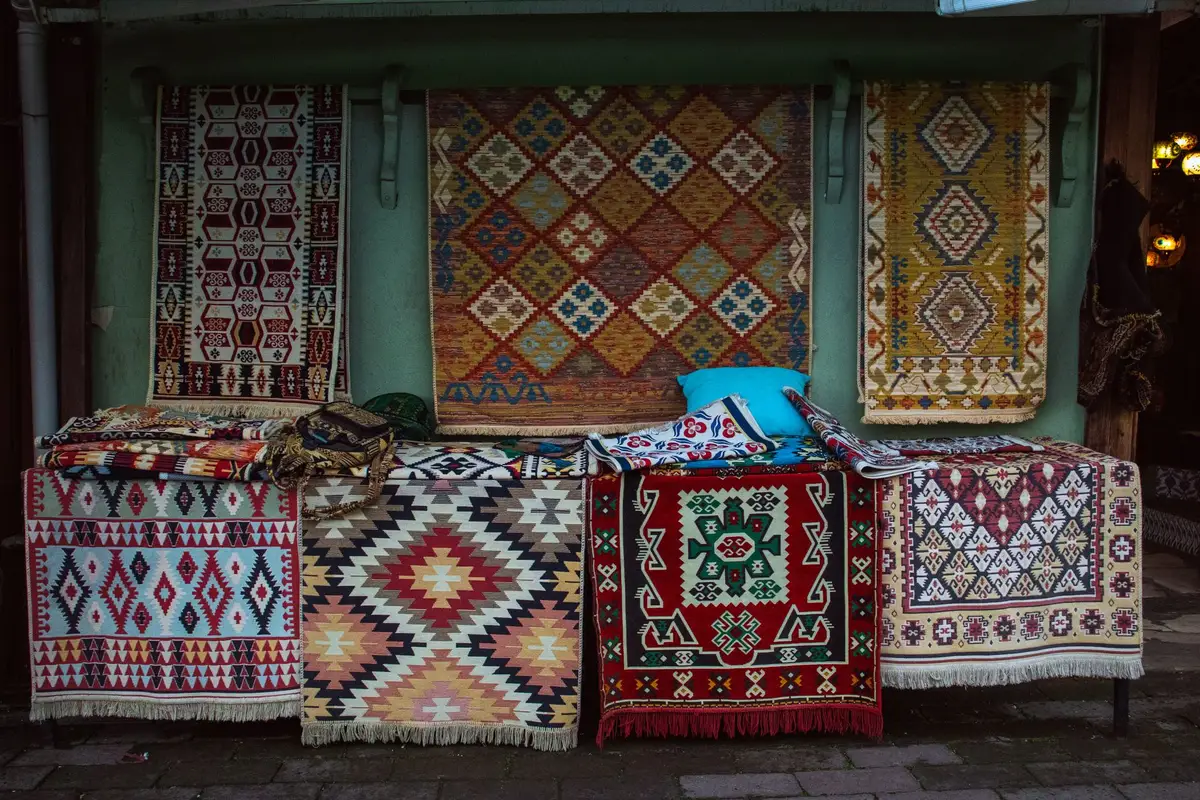 Handwoven fabrics and traditional crafts displayed at an artisan fair in a heritage setting