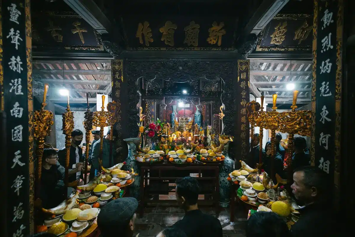Woman participating respectfully in a Hindu temple festival with colorful flowers and ritual offerings