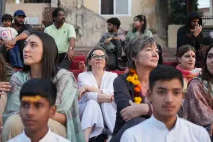 A young person meditating at temple steps during dawn with mist and water visible