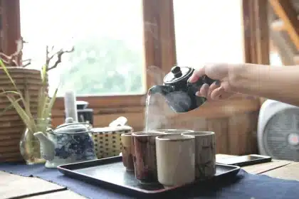 Steaming masala chai being poured into cups at a café counter