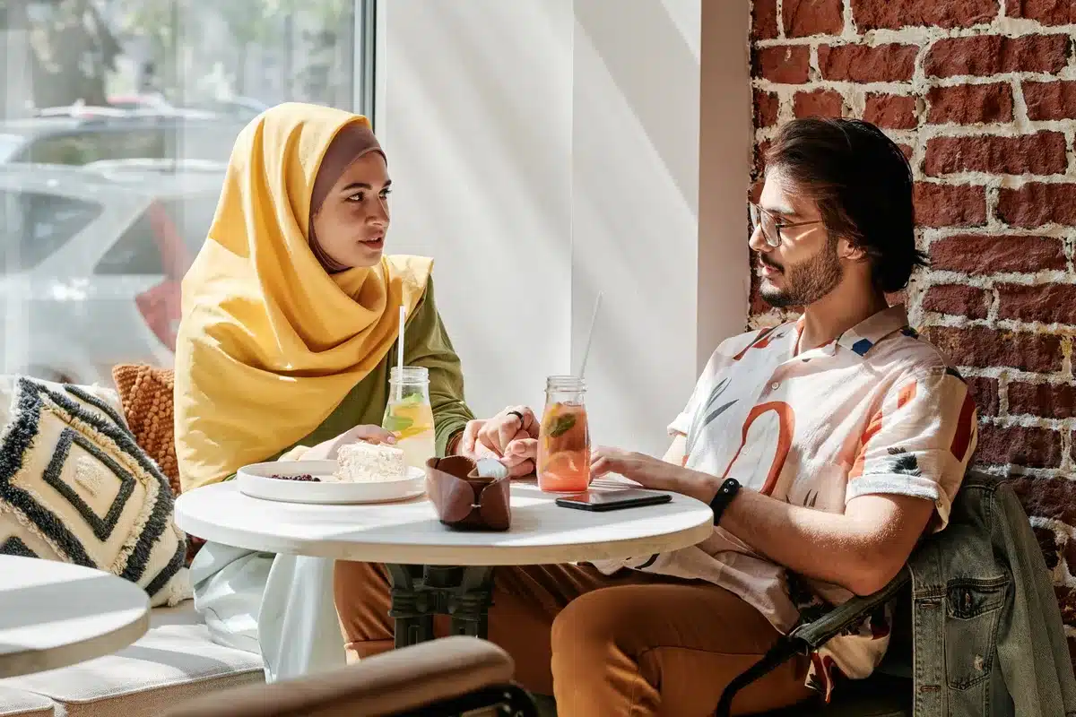 Diverse couple in thoughtful conversation, representing cross-cultural understanding and respect.