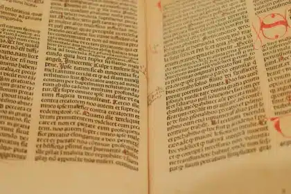 Weathered ancient manuscript with Tamil script on palm leaves, hands turning pages in candlelit study