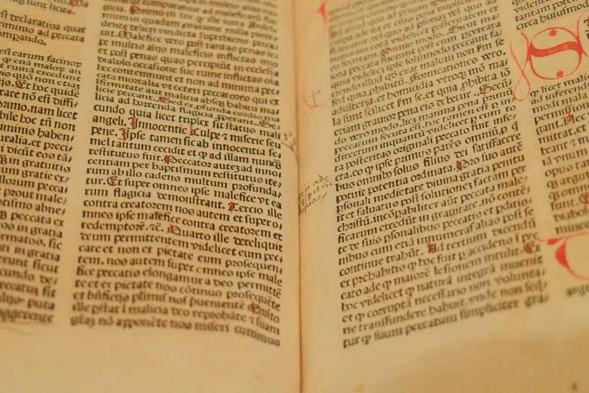 Weathered ancient manuscript with Tamil script on palm leaves, hands turning pages in candlelit study