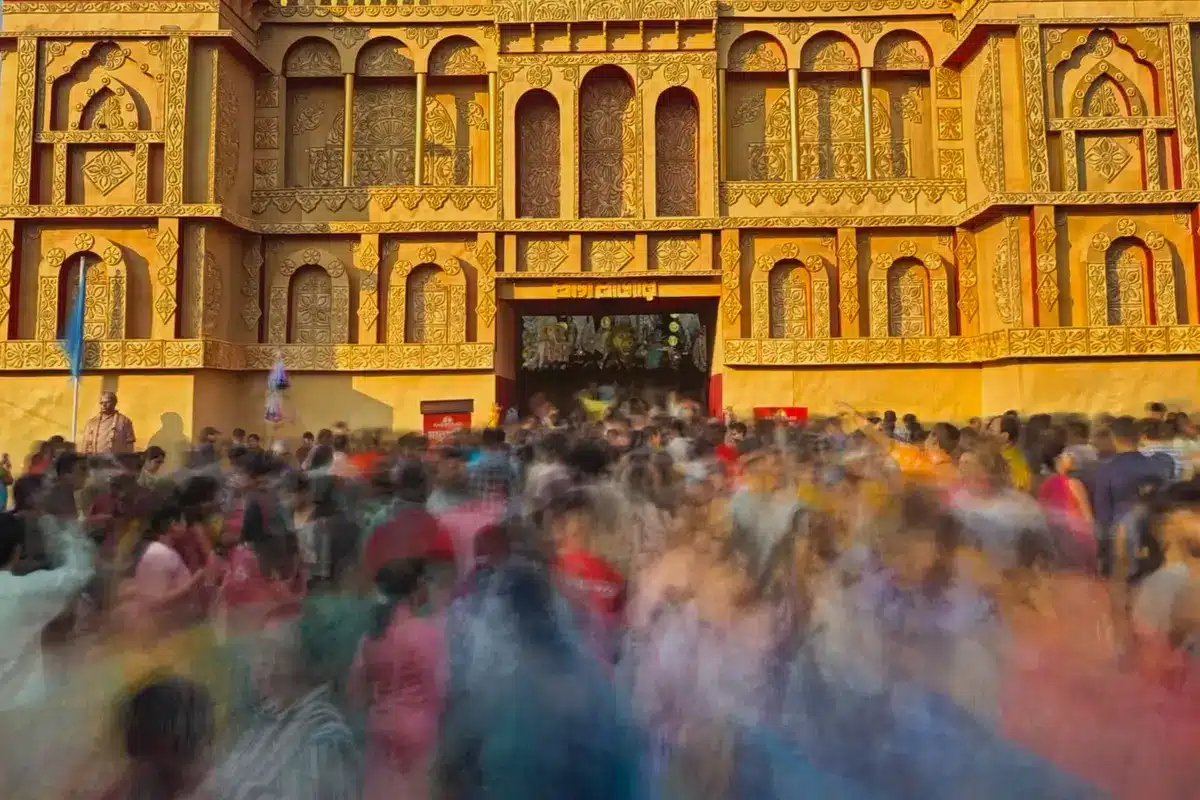 Diverse crowd celebrating at a Hindu festival with traditional flags and temple in background