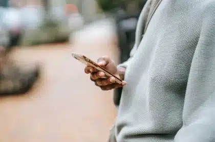 Person scrolling through a social media feed on a smartphone, surrounded by digital notifications and content fragments