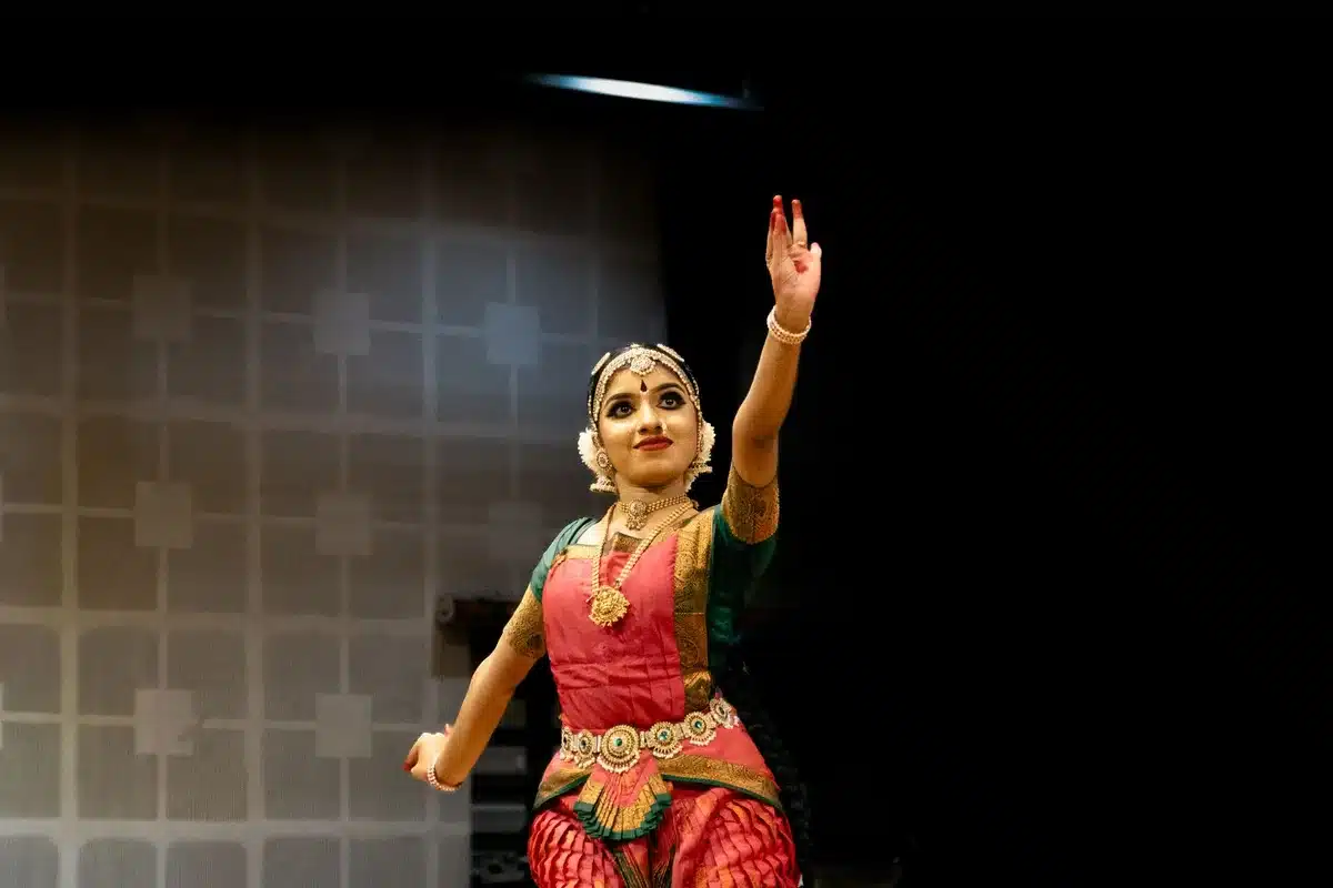 A classical Indian dancer in traditional costume performing an expressive movement