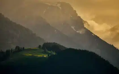 Anonymous pilgrims walking toward a small ashram on a Kumaon hillside at sunset