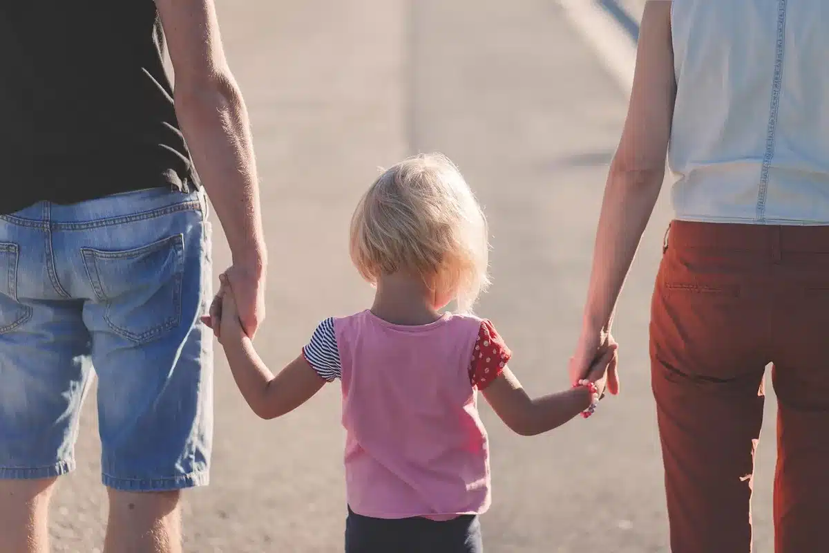 Parent hand guiding a child's hand while teaching