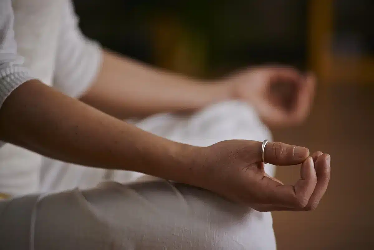 Hands holding prayer beads during morning meditation practice