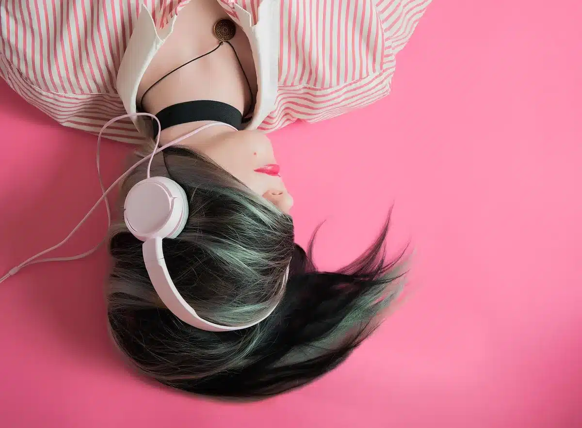 Person trägt Kopfhörer und hört konzentriert Musik