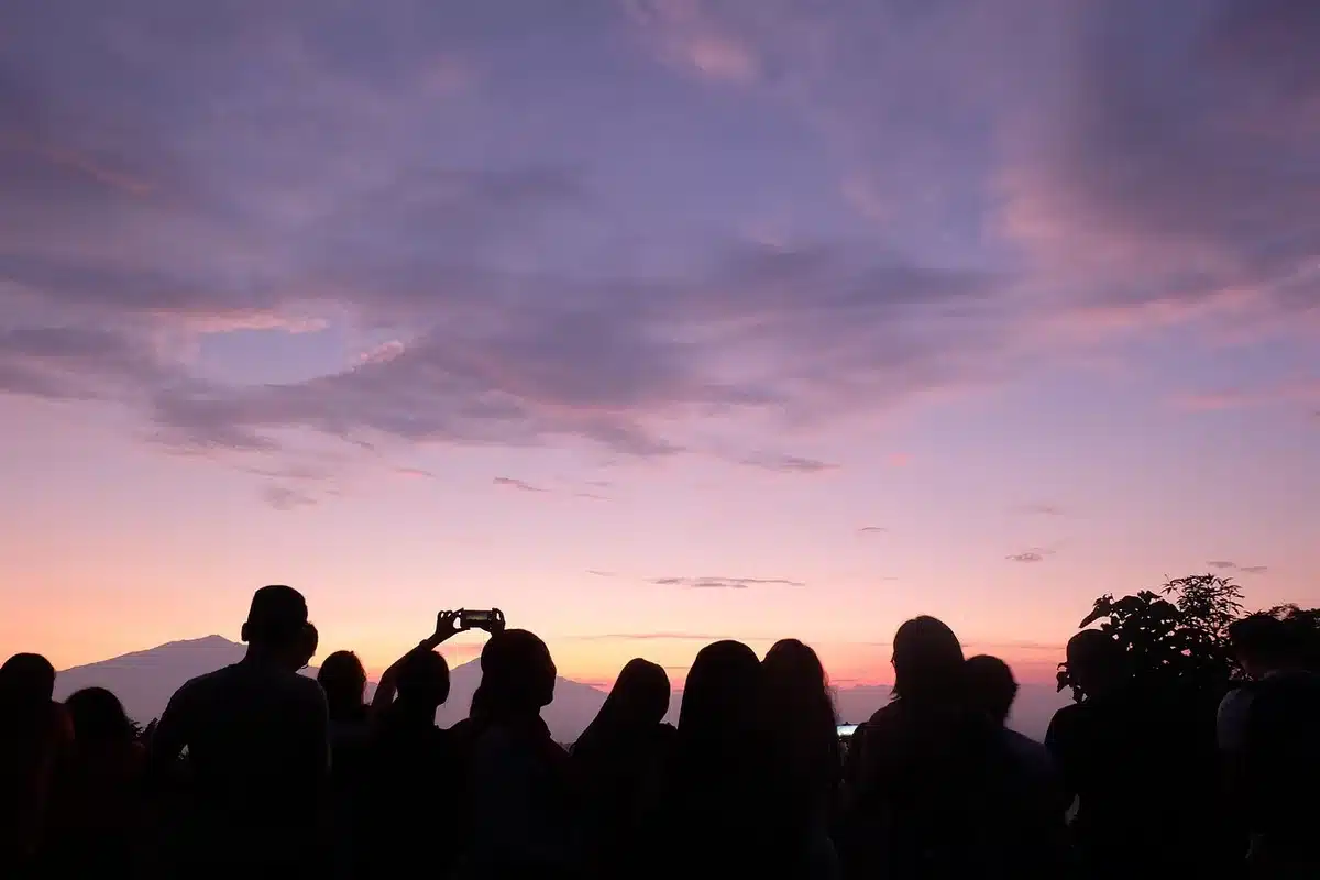 Silhouette d'une cour de temple au crépuscule avec guirlandes et lampes