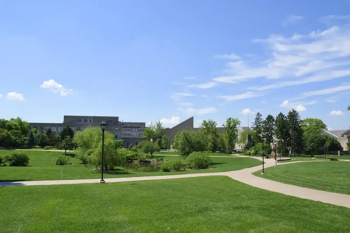 Students from different backgrounds walking together on a university campus with modern and traditional buildings