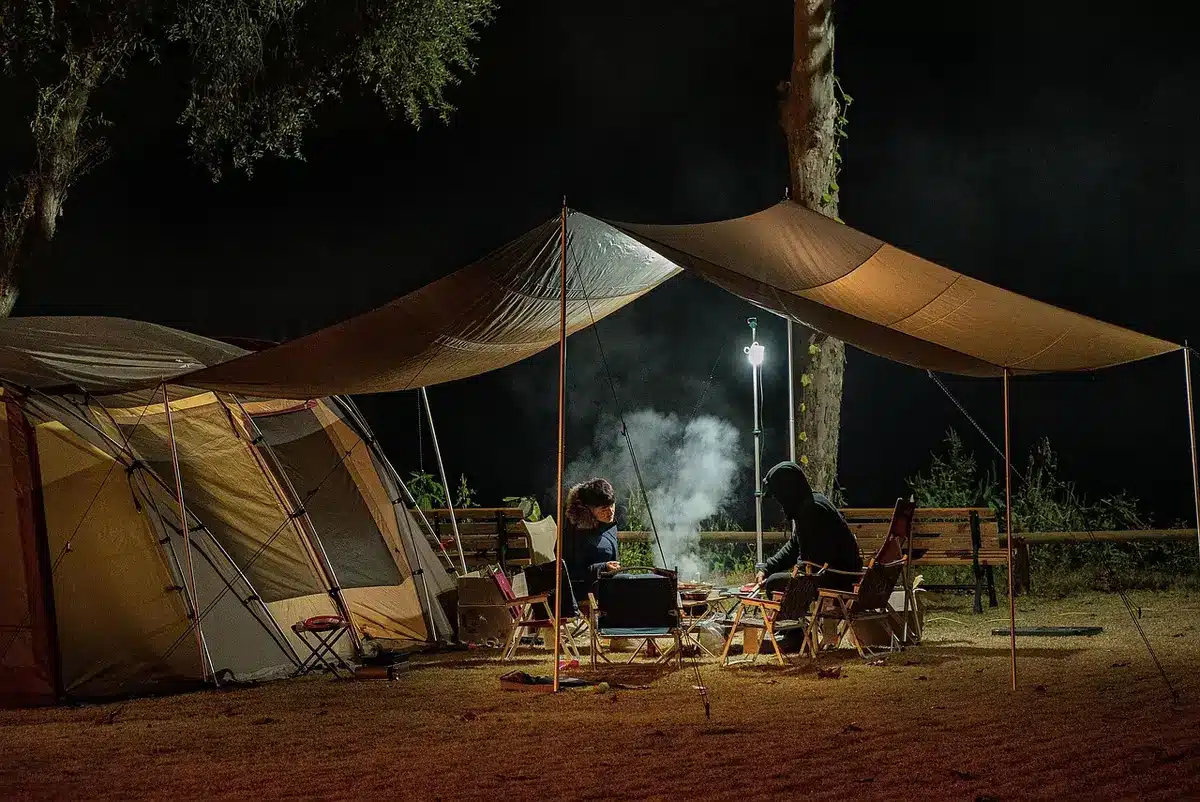 A makeshift hospital tent with medical staff and patients in a relief setting