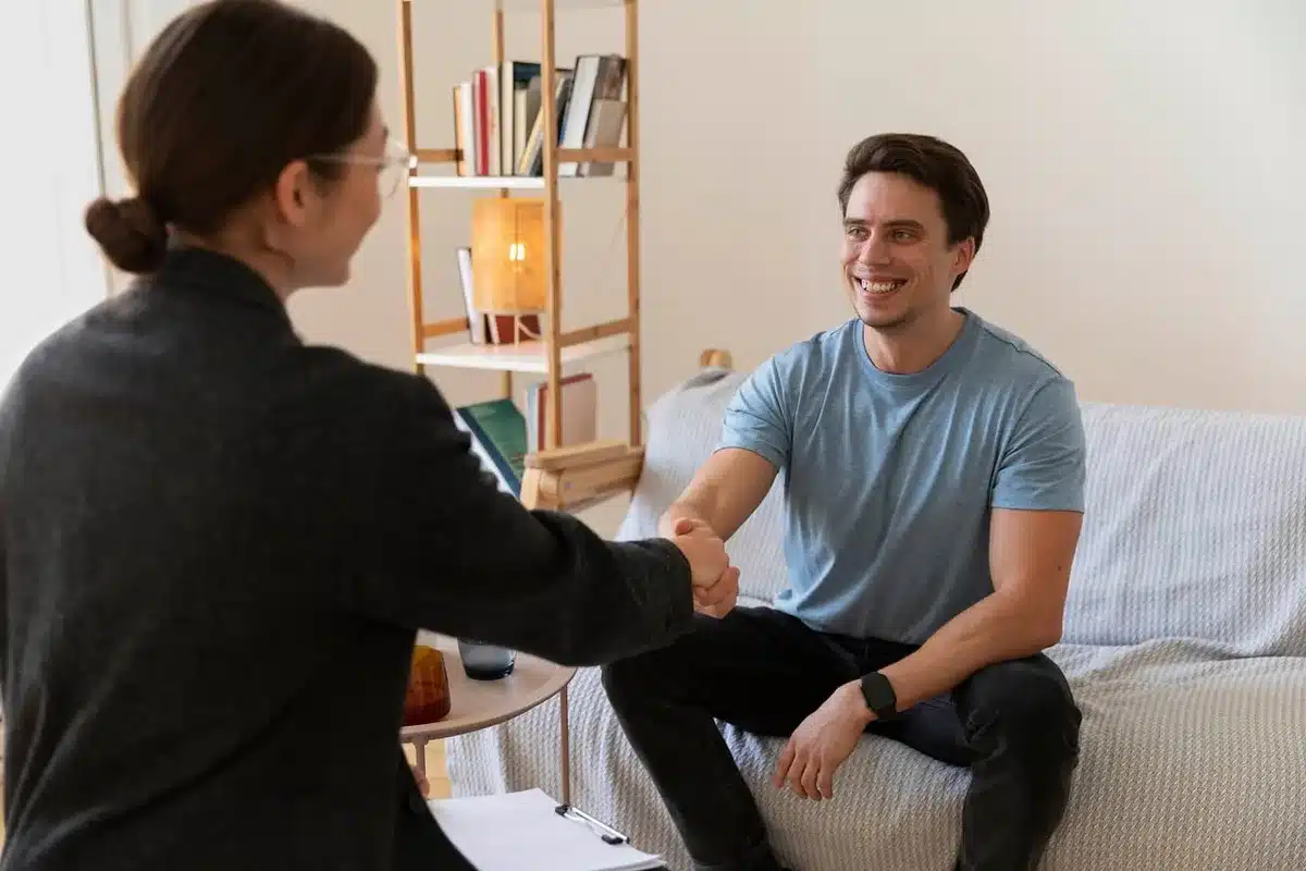 An anonymous activist speaking with a survivor in a simple office