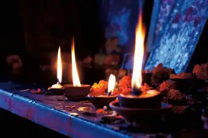 Doorway with oil lamp, rangoli and brass utensils at dusk