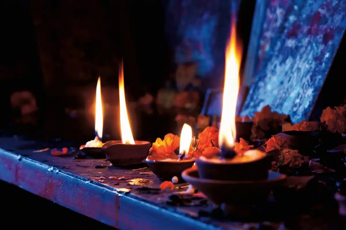 Doorway with oil lamp, rangoli and brass utensils at dusk
