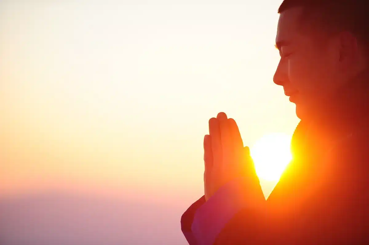 Close-up of hands holding prayer beads to illustrate faith and practice
