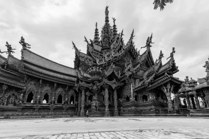 Temple courtyard with folded-hands sculpture and a carved monkey figure in soft daylight
