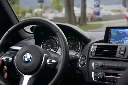 Congested urban road with blurred cars and an anonymous driver holding a steering wheel
