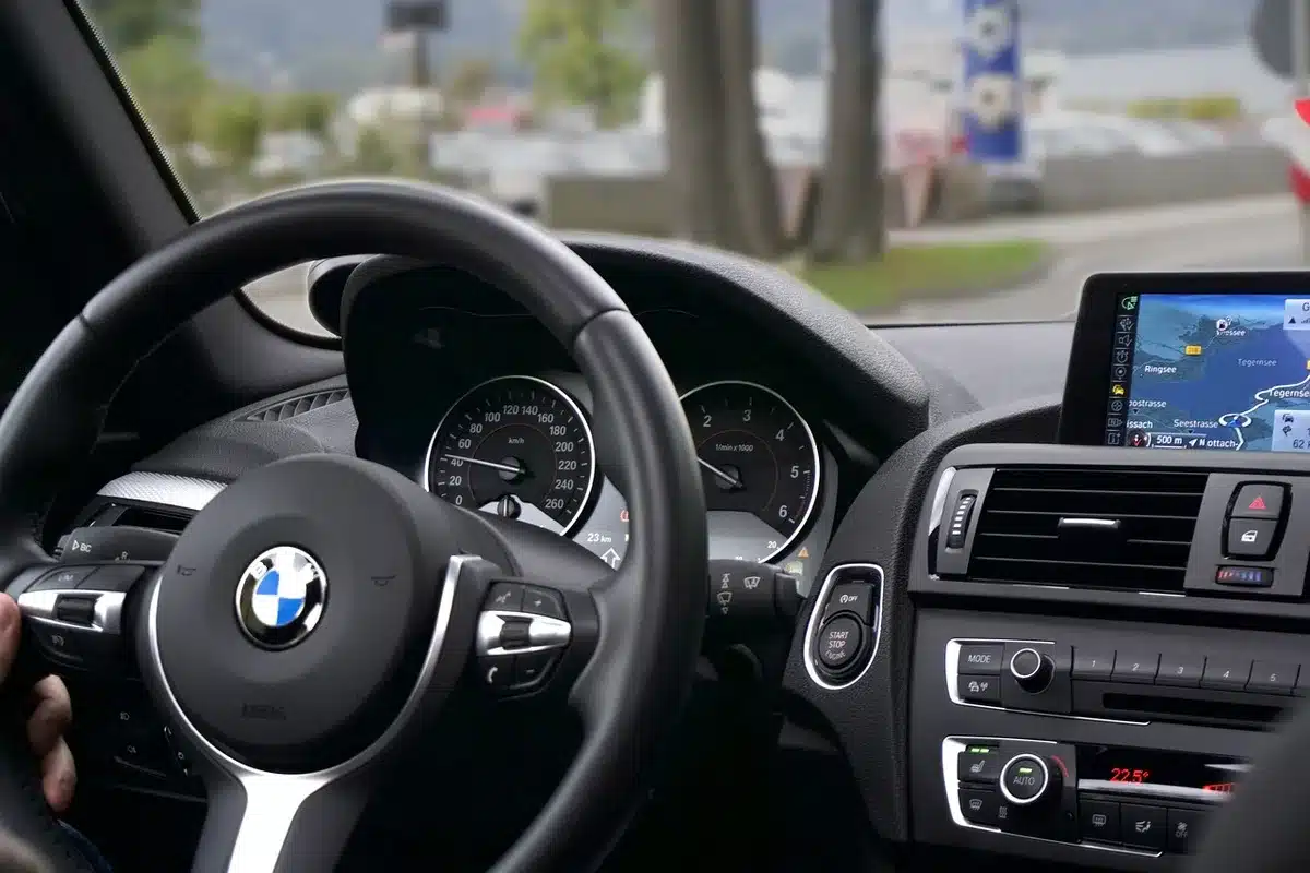 Congested urban road with blurred cars and an anonymous driver holding a steering wheel