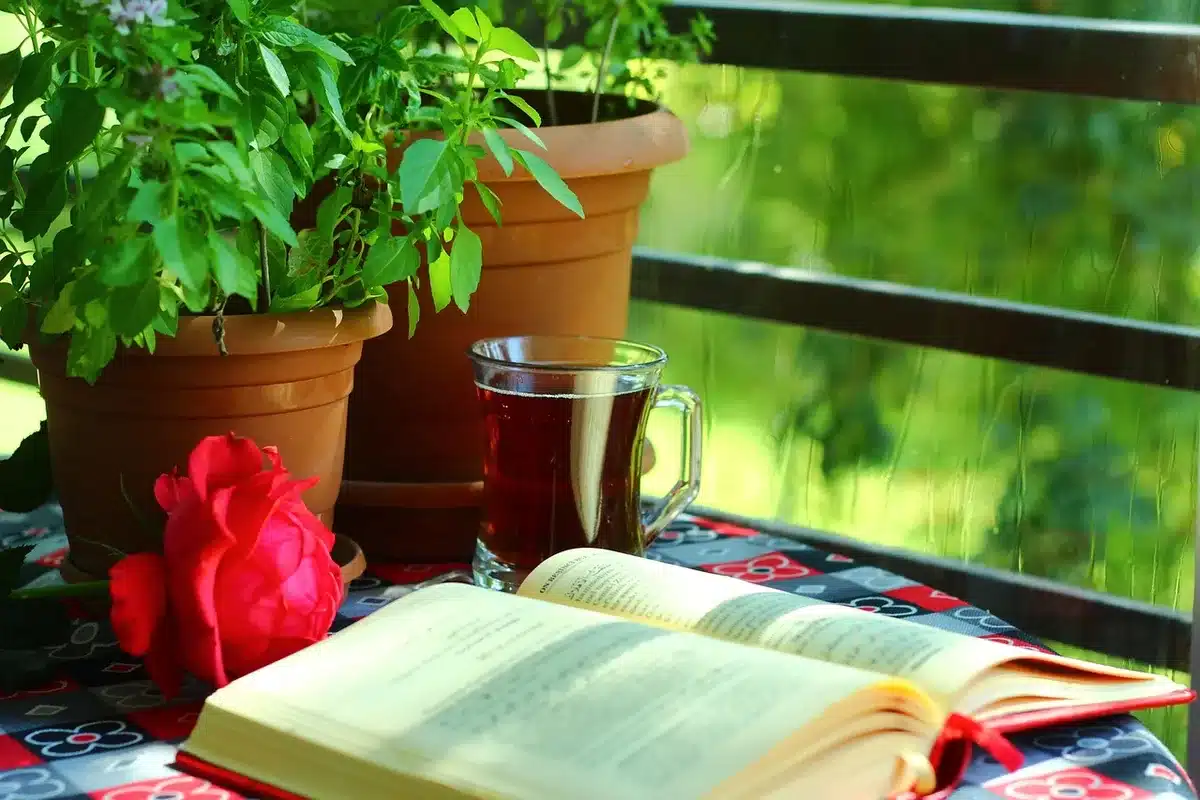 Open Urdu poetry book beside traditional dishes and tea