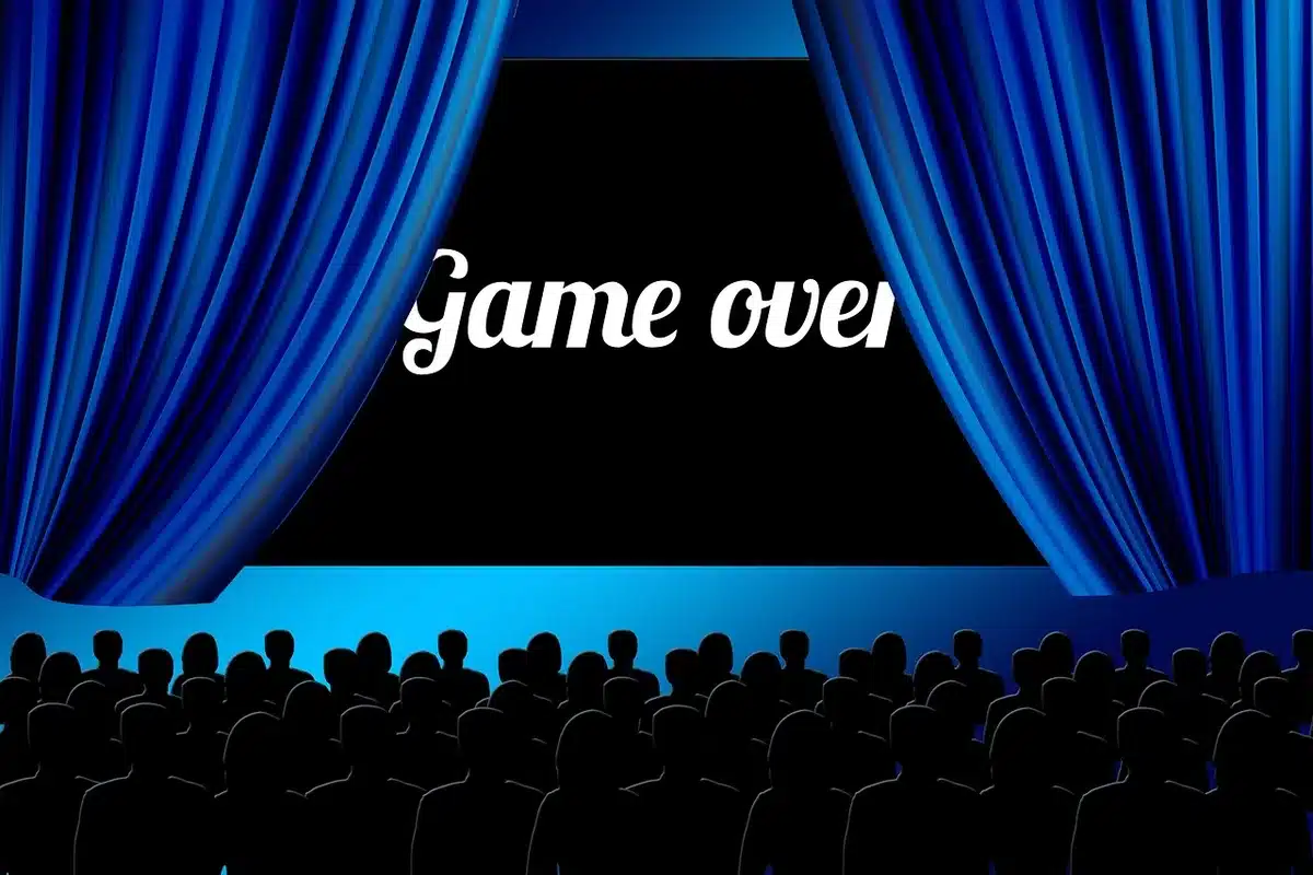 Audience watching a film in a small theatre, some holding programmes