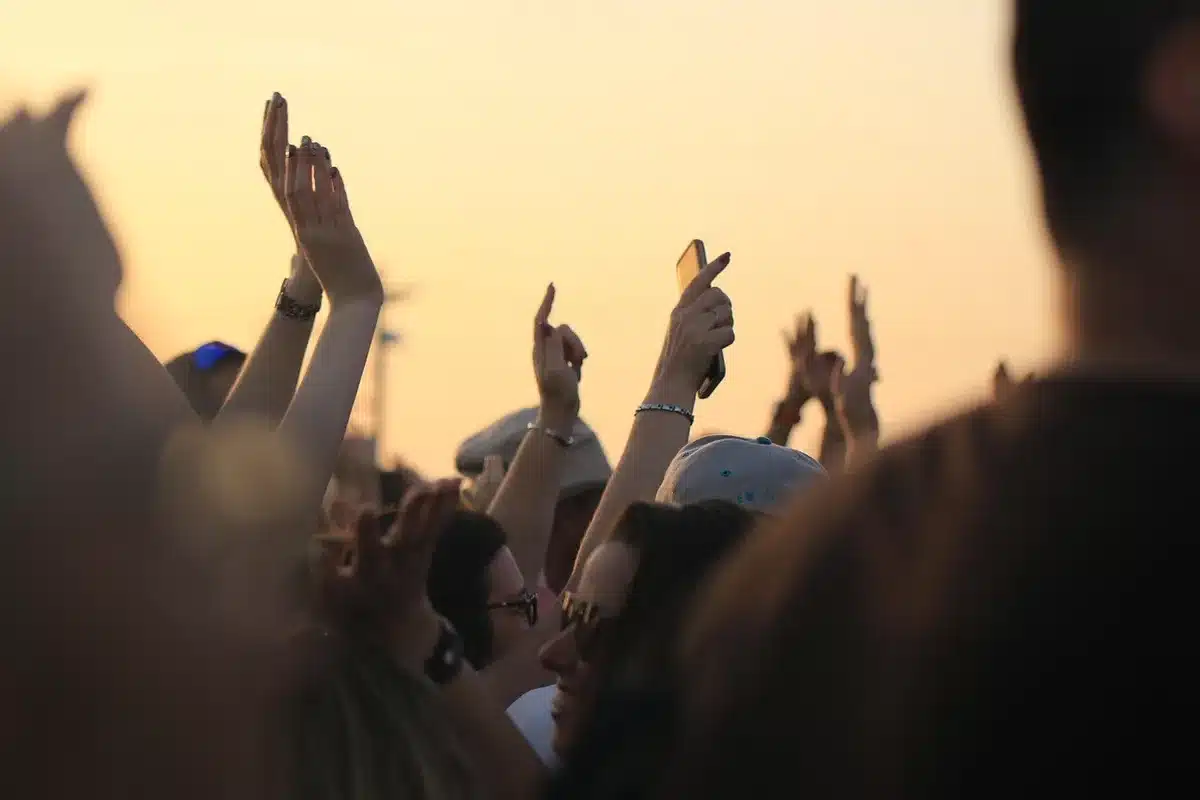 Crowd gathered at an outdoor memorial concert with candles